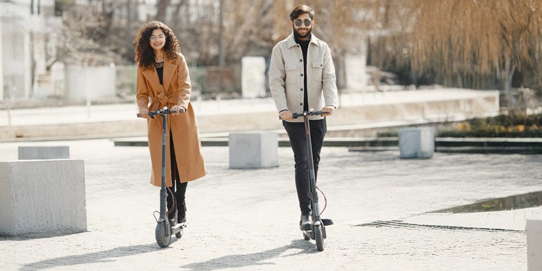 Mann und Frau fahren auf E-Scootern