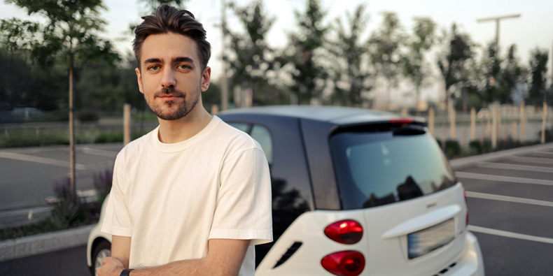Mann steht vor seinem Auto