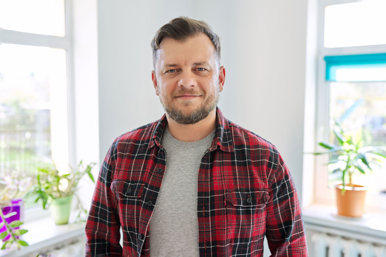 Zufriedener Kunde des OEV Experience Hub in seinem Wohnzimmer stehend