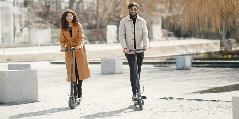 Mann und Frau fahren auf E-Scootern